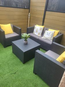 a patio with wicker chairs and a table with a plant at Studio chic meublé et lumineux in Chauray
