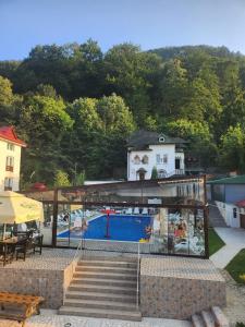 a house with a swimming pool and stairs next to a building at Vila Crinilor Căciulata in Căciulata