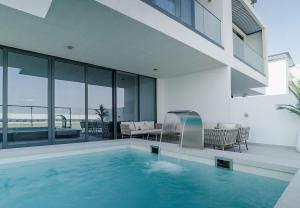a swimming pool in a house with a view of the ocean at Blausee Beachfront Villa with Private Pool in Al Ḩamrīyah