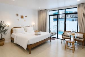 a hotel room with a bed and a table and chairs at Beachfront Pool Access Apartment FREE Disney Plus in Bangsaen