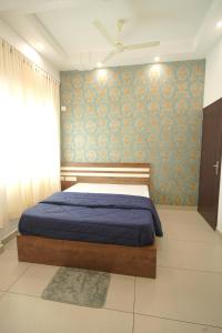 a bedroom with a bed and a blue wall at KPN Tower in Erāttupetta