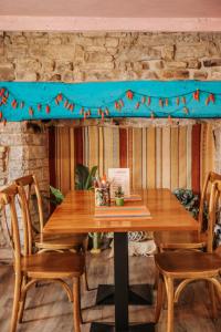a wooden table with chairs and a blue banner at Northover Manor Hotel in Ilchester