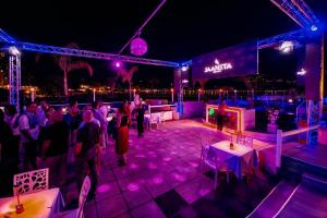 a group of people standing on a stage at night at Mare Blu in Giardini Naxos
