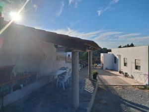 a patio with a table and chairs and a roof at Quinta das Reveladas in Marvão