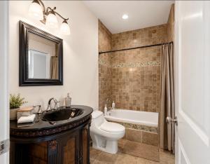 a bathroom with a sink and a toilet and a tub at Seaview Executive Home in Ladysmith +15 photos