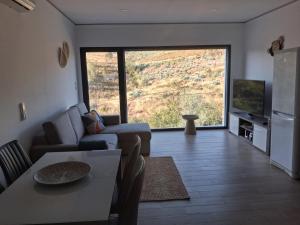 a living room with a couch and a large window at Quinta das Reveladas in Marvão