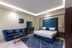 a hotel room with a bed and a blue couch at Alqasr Almutar Hotel in Abha +24 photos