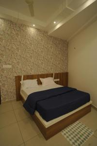 a bedroom with a bed with a blue comforter at KPN Tower in Erāttupetta