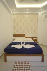 a bedroom with a bed with two white towels at KPN Tower in Erāttupetta