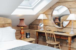 a bedroom with a bed and a desk with a mirror at Owl Barn in Little Milton