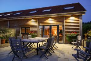 a wooden table and chairs on a patio at Owl Barn in Little Milton