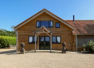 a wooden house with a glass door in front of it at Owl Barn in Little Milton