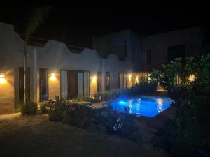 a house with a swimming pool at night at Villa tawarda in Oumnas