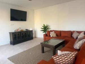 a living room with a couch and a tv at Villa tawarda in Oumnas