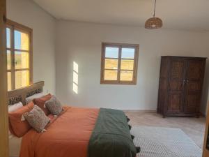a bedroom with a large bed and a window at Villa tawarda in Oumnas +25 photos