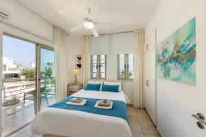 a bedroom with a large bed and a balcony at Fig Tree Beach Villa Two in Paralimni +96 photos
