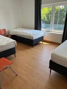 a room with two beds and a window at Guesthouse Kriebeke in Tielt