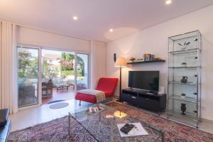a living room with a red chair and a television at Bia in Almancil