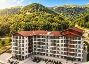 an aerial view of a hotel with mountains in the background at Cozy Ski-In Studio near forest at Crystal residence in Bakuriani