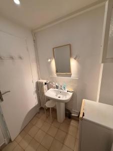 a white bathroom with a sink and a mirror at Twin room in Nice