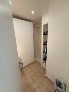 a bathroom with white walls and a tiled floor at Twin room in Nice