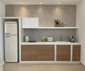 a kitchen with a white refrigerator and a sink at Salvia di Astypalea in Livadi Astypalaias