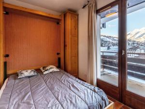 a bedroom with a bed and a large window at Studio 3*** aux pistes, cheminée, animaux admis, garage - FR-1-304-111 in La Clusaz