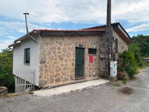a small stone building with a green door at Cabana do Sil in Forcas