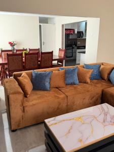 a living room with a brown couch with blue pillows at Selah House in Harare +9 photos
