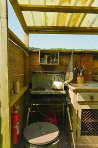 a kitchen with a stove and a toilet in a house at Devon Belltents - Beesands in Kingsbridge