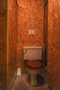 a bathroom with a toilet with a wooden seat at Devon Belltents - Beesands in Kingsbridge