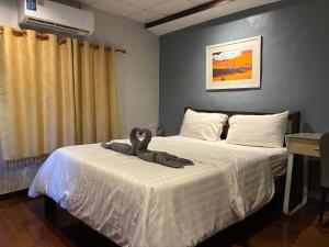 a room with two beds with a stuffed animal on it at Noom Guesthouse in Lop Buri