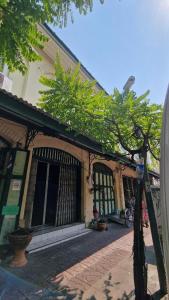 a building with a tree in front of it at Thai Traditional Home in Bangkok