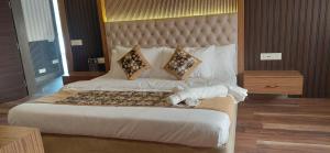 a bedroom with a large bed with a large headboard at Landmark Resort in Sonīpat