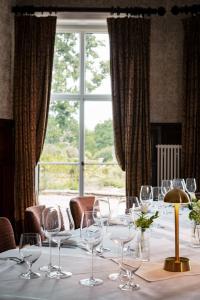 a table with wine glasses on it in front of a window at Rookery Hall Hotel & Spa in Nantwich