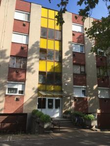 an apartment building with yellow and red windows at Móra Corner Apartman Mezőkövesd in Mezőkövesd