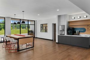 a kitchen and living room with a table and chairs at StudioRes by Marriott Greensboro Airport in Greensboro