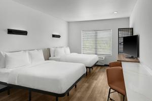 a hotel room with two beds and a flat screen tv at StudioRes by Marriott Greensboro Airport in Greensboro