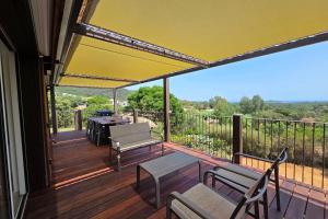 a deck with a bench and a grill on it at CASA FUNTA - villa T5 - vue mer- piscine in Sainte-Lucie de Porto-Vecchio