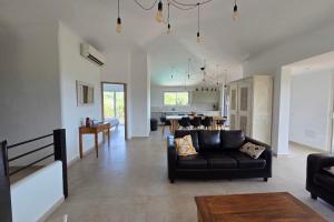 a living room with a couch and a dining room at CASA FUNTA - villa T5 - vue mer- piscine in Sainte-Lucie de Porto-Vecchio