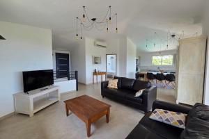 a living room with a couch and a table at CASA FUNTA - villa T5 - vue mer- piscine in Sainte-Lucie de Porto-Vecchio +13 photos