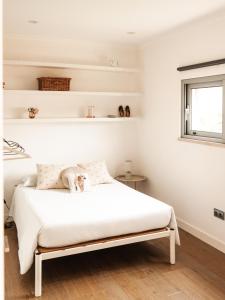 a bedroom with a white bed with a dog on it at L'École Villa Nature in Abrantes