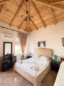 a bedroom with a bed and a wooden ceiling at Q Bay Apartments in Qeparo +28 photos
