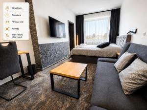 a living room with a couch and a bed at Olympland Hotel in Trutnov