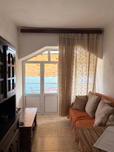 a living room with a couch and a large window at Q Bay Apartments in Qeparo