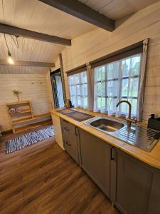 a kitchen with a sink and a large window at Cozy house for your holidays in Bernāti