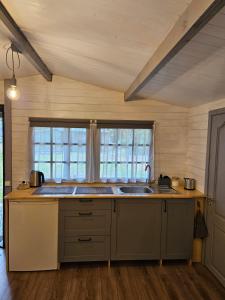 a kitchen with a counter and a sink and a window at Cozy house for your holidays in Bernāti +8 photos