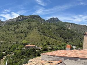 a view of a mountain with a house in front at Studio with sea and mountain view in Sainte-Agnès