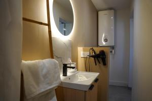 a bathroom with a sink and a mirror at 1 Peraudel Suite & Appartements in Castres +35 photos