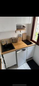 a kitchen with white cabinets and a wooden counter top at Studio with sea and mountain view in Sainte-Agnès